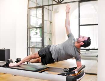 Plank samping dengan rotasi menargetkan otot inti, khususnya obliques